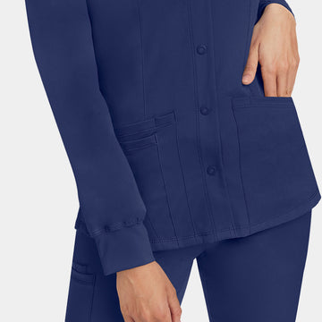 Healing Hands Megan women's navy button front scrub jacket with model's hand in front pocket